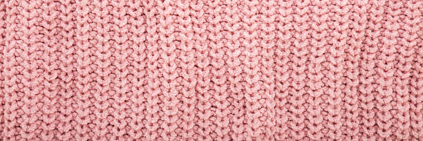 istock Light pastel pink soft knitted fabric pattern background. Closeup. Wide banner. Top down view. 2215024169