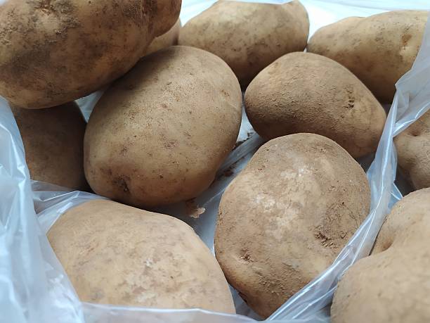 istock Some potato vegetables in white plastic on a white background 2215028378