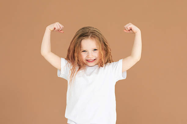 istock Victory. Cheerful Girl Gesturing like winning Smiling To Camera Standing Over brown Studio Background. Panorama, Studio Shot 2215028461