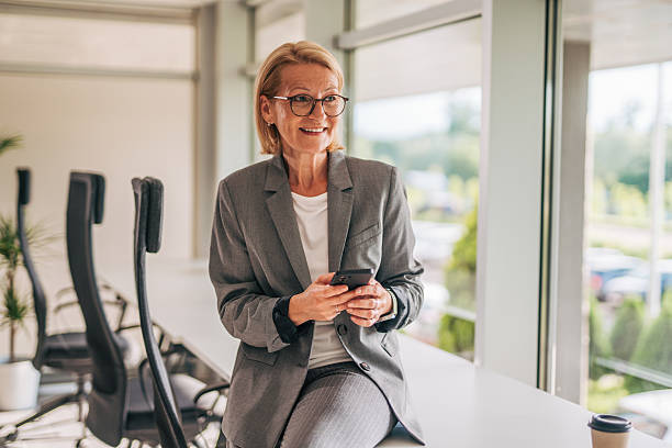 istock Senior businesswoman using smartphone in modern office 2215029617