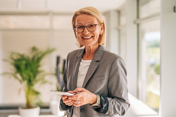 istock Smiling senior businesswoman using digital tablet in modern office 2215030813