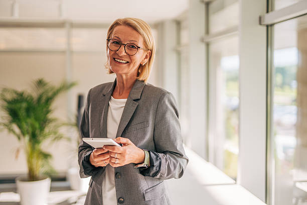 istock Smiling senior businesswoman using digital tablet in modern office 2215030854