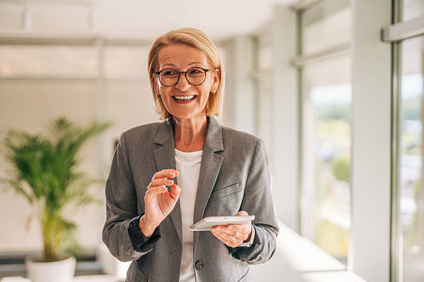 istock Senior businesswoman smiling and using digital tablet in office 2215030944