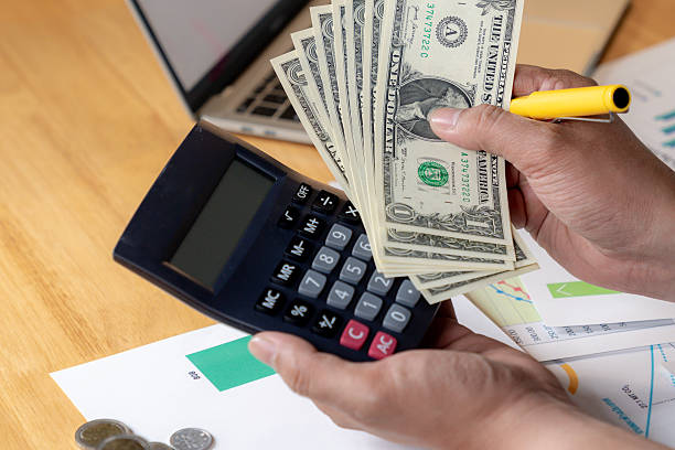 istock Partial view of hands using a calculator and writing down expenses, concept of personal finance management 2215031472