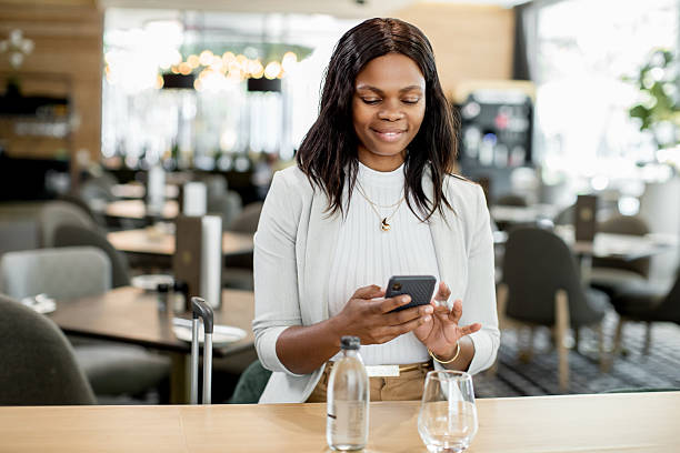 istock Traveling businesswoman using a phone in a Lobby while waiting 2215031904