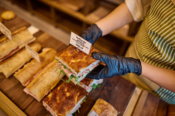 istock Saleswoman serving a delicious sandwich in a bakery 2215032025