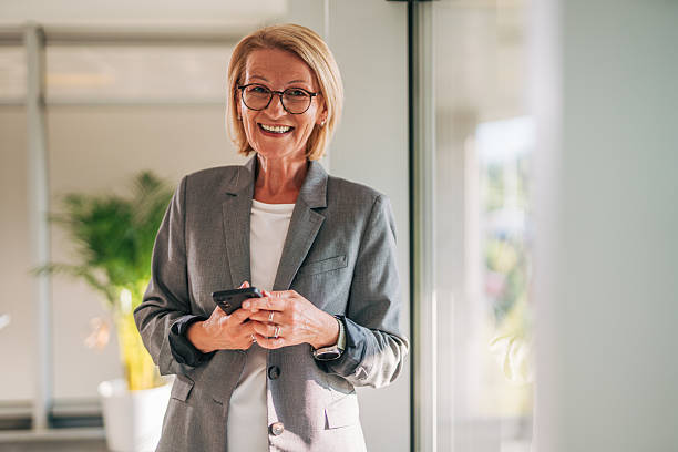istock Smiling senior businesswoman using smartphone in office 2215032888