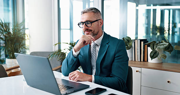istock Business man, thinking and insight on laptop for problem solving, investment idea or evaluation. Computer, mature or happy corporate manager reading financial email for decision or planning in office 2215035133