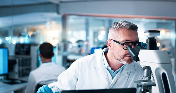 istock Research, man and scientist with microscope in laboratory for medical study with DNA analysis. Experiment, investigation and male biologist with biotechnology for clinical trial for innovation. 2215035617