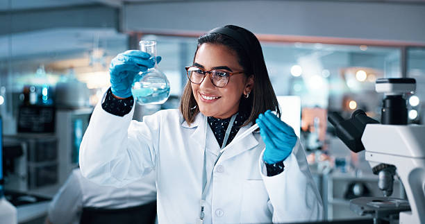 istock Liquid, woman and scientist with beaker in laboratory for pharmaceutical experiment, research or innovation. Chemical, glass and female medicinal chemist with formula, reaction observation or cure. 2215035621