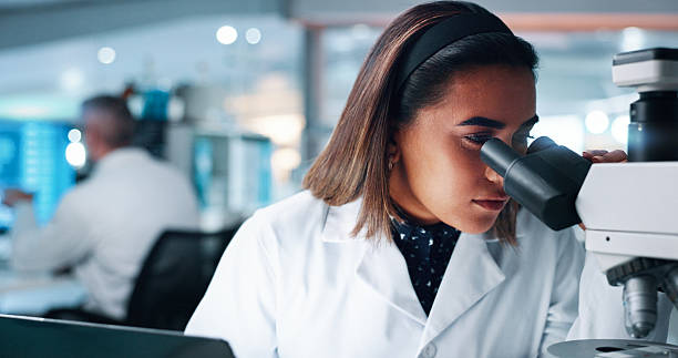istock Scientist, woman and microscope in lab, study and process for medical research for human genome sequence. Person, review and test for sample with clinical trial, investigation and DNA analysis 2215035652