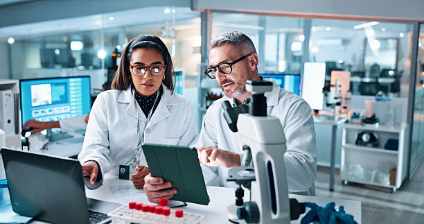 istock Collaboration, tablet or science with people in lab together for research or development. Innovation, tech and microscope with scientist team in clinical trial for planning or medical investigation 2215035680