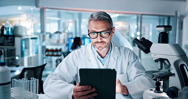 istock Mature man, scientist and tablet at laboratory for medical research with human genome sequence. Person, touchscreen and clinical trial with application, investigation and DNA analysis for pharma job 2215035733