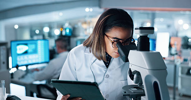 istock Research, woman and scientist with microscope in laboratory for medical study with DNA analysis. Experiment, investigation and male biologist with biotechnology for pharmaceutical clinical trial. 2215035749