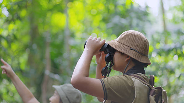 istock Asian Teen Birdwatching in Forest with Binoculars 2215037613