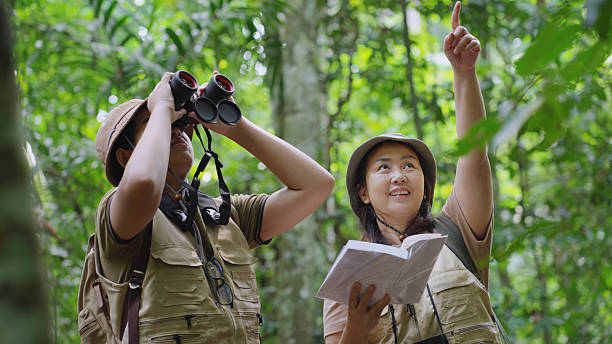 istock Asian Family Birdwatching with Binoculars and Guidebook – Front View 2215037677
