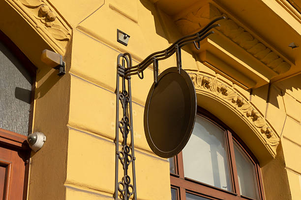 This decorative outdoor sign is elegantly mounted on a bright yellow wall, showcasing unique architectural features and details