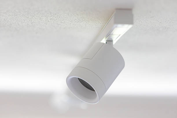 istock Modern white cylindrical track lighting illuminating a textured ceiling 2215041262