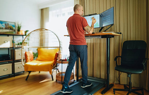 istock Man working at standing desk with treadmill in home office 2215045820