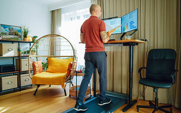 istock Man working at standing desk with treadmill in home office 2215046650