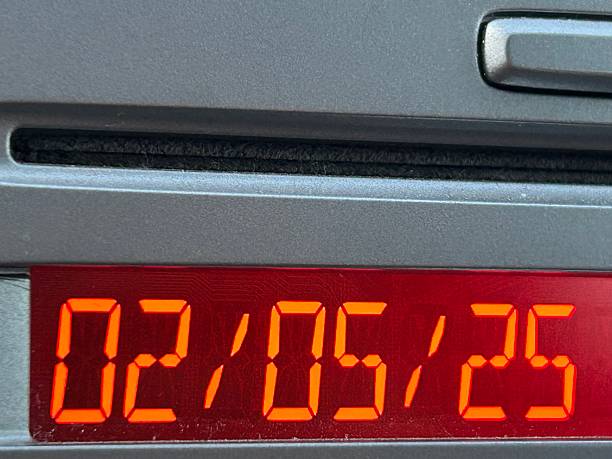 istock Digital clock inside of car showing 2nd May 2025, Orange display 2215048007