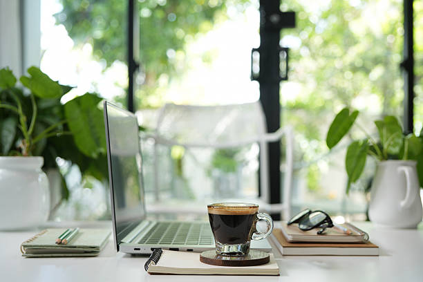 istock Laptop side view and coffee glass cup and notebook, cozy indoor workspace 2215057450