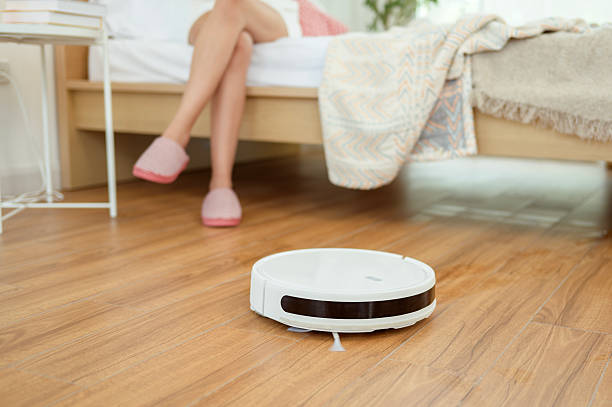 istock Young asian woman relaxing while Robotic vacuum cleaner working 2215058335
