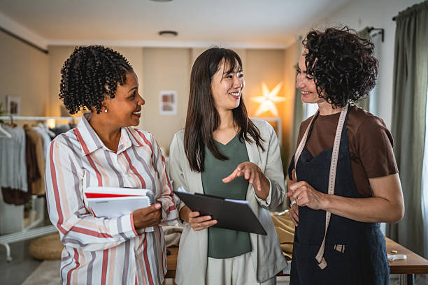 istock caucasian female tailor shows her work and studio to supervisors 2215059714