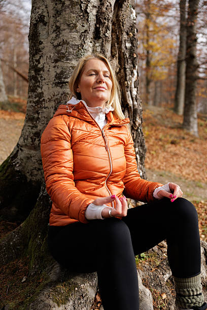 istock Woman Meditates Peacefully in Autumn Forest Setting 2215063003