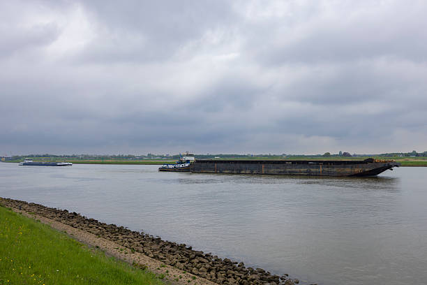 istock Tugboat pushing barge on river under cloudy sky in Alblasserdam, Netherlands 2215063027