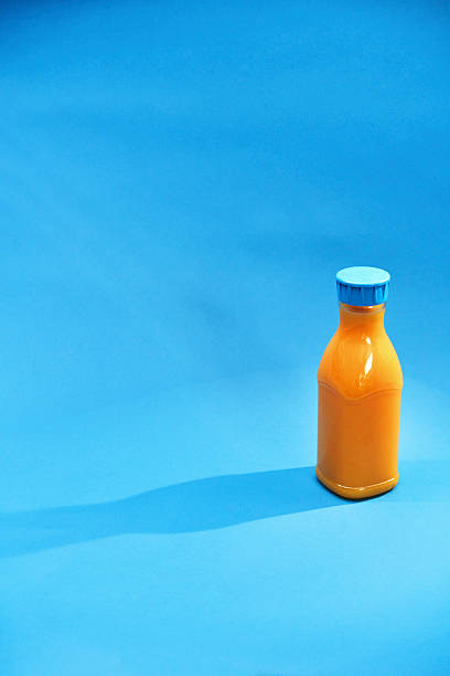 istock Orange Juice in Recycled PET Plastic Bottle on Blue Background 2215063616