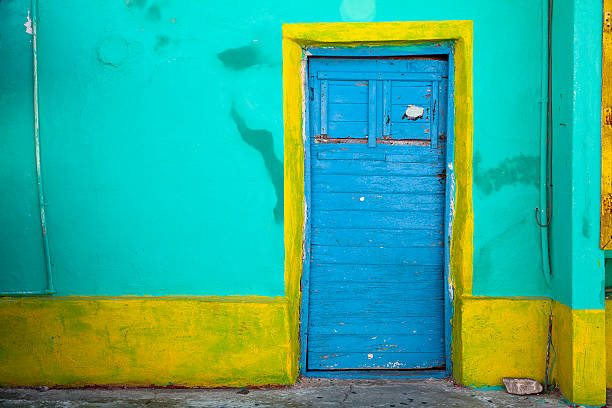 Havana, Cuba, March 15, 2022: Large wooden colonial door at the entrance of a former palace in Old Havana. There are no people and the street is made from cobblestone. This area is a Unesco World Heritage Site and a major tourist attraction.