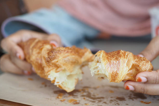 istock A Delicious Croissant is Being Torn Apart by Two Hands Now 2215065562