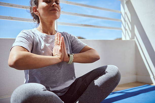 Woman Meditating Outdoors in the Sunlight While Practicing Yoga in a Peaceful Environment on a Relaxing Day