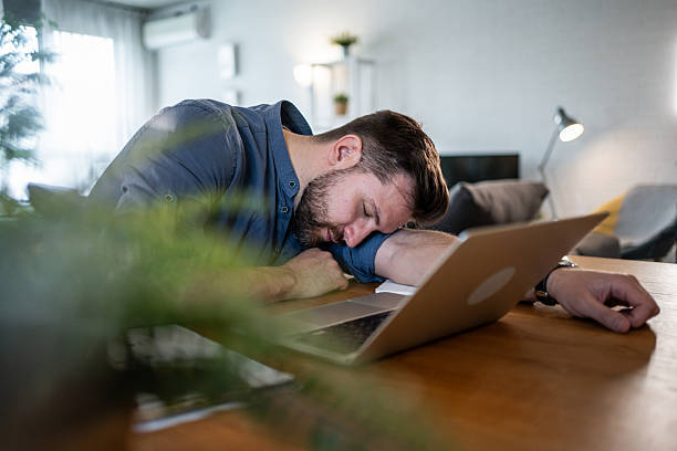 istock Exhausted businessman sleeping on laptop at home office 2215071370