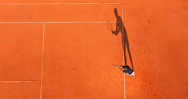 istock Tennis Player Practicing on a Clay Court with a Long Shadow 2215074979