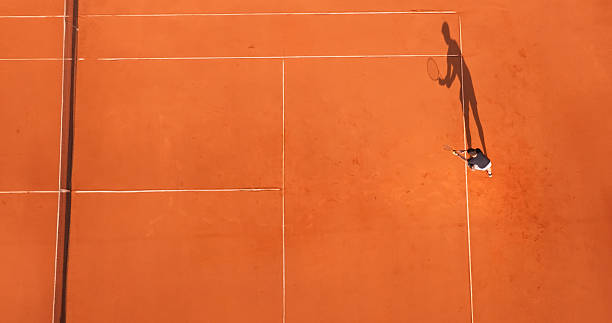 istock Tennis Player Serving on a Clay Court with Visible Shadow 2215074985