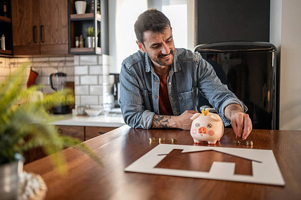 istock Man saving money for new house using piggy bank 2215075589
