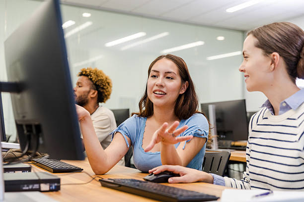istock Two Young Women Students Collaborate Using Laptop in Classroom 2215083904