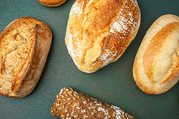istock Freshly baked artisan bread loaves on a rustic table in natural light 2215088945