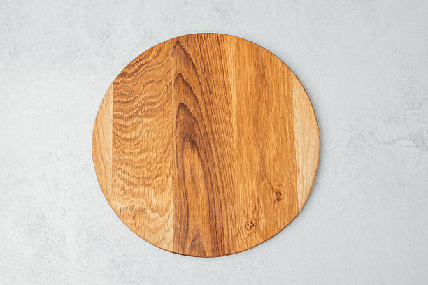 istock Round wooden cutting board resting on a light surface in a kitchen setting 2215088954