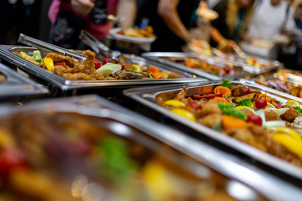 istock Catering spread featuring diverse dishes with vibrant colors at an event in a bustling hall 2215091307
