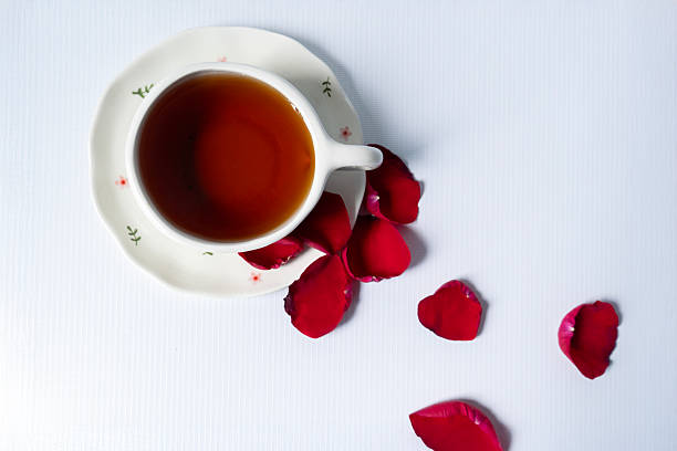 istock Top view of tea cup with scattered rose petals. 2215093173