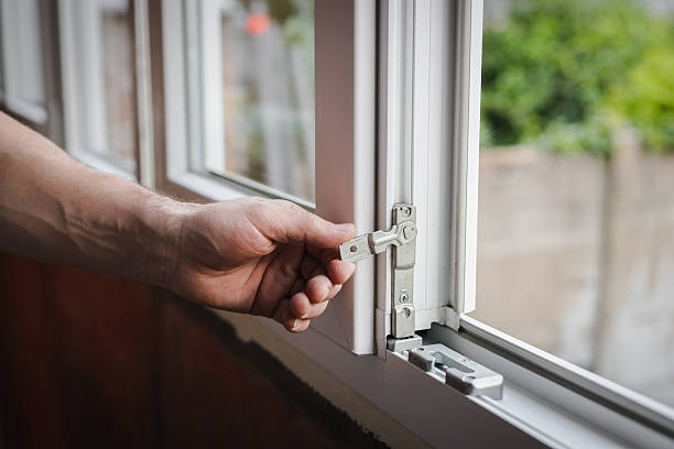 istock One young worker installs fittings on a plastic window frame. 2215094019