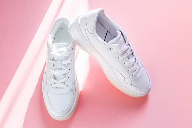 istock White sneakers on a pink background. 2215096843
