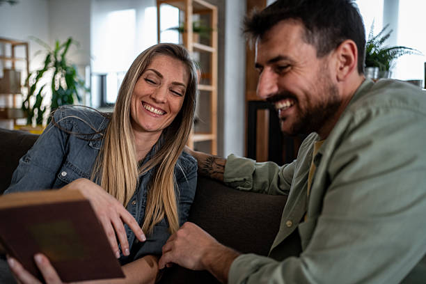 istock Couple reading a book and having fun at home 2215098981