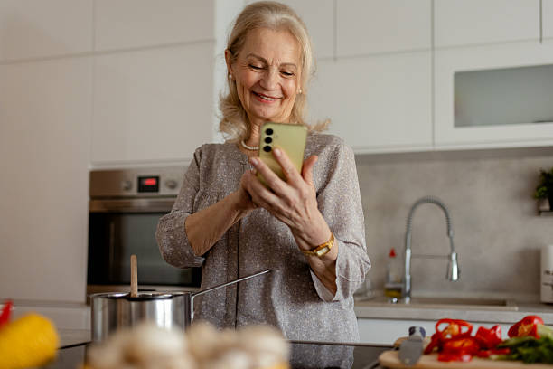 istock Elderly Woman Browsing Quick Meal Ideas on Smartphone 2215099565