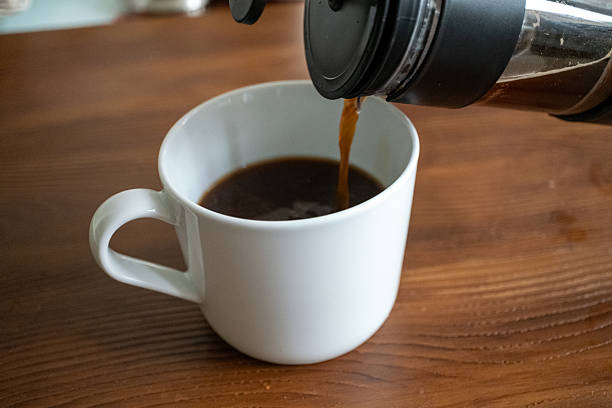 istock Brewing and pouring coffee with black french press on table 2215104221