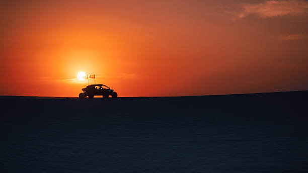 Sealine, Qatar - February 24, 2025: Off-road vehicles race over golden sand dunes, creating an exhilarating desert adventure under the vast sky