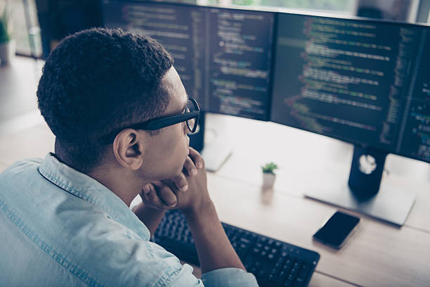 istock Back rear view photo of geek nerd man thinking fixing his bug on computer monitor javascript programmer indoors office workspace location 2215108515